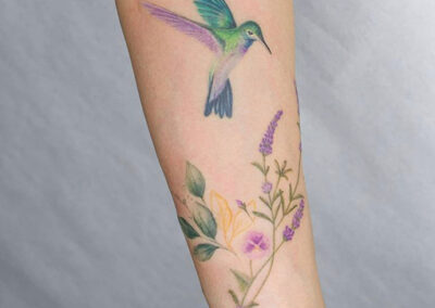 tatuaje en el brazo mujer de colibri