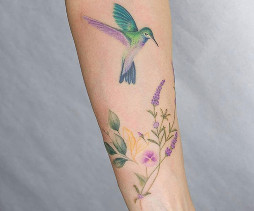 tatuaje en el brazo mujer de colibri