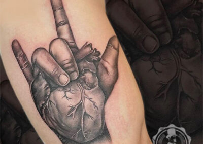 tatuajes realistas de un corazón en la mano