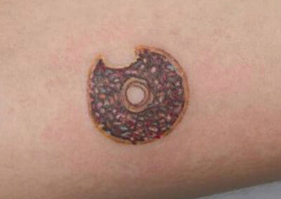 tatuaje de una rosquilla en el brazo