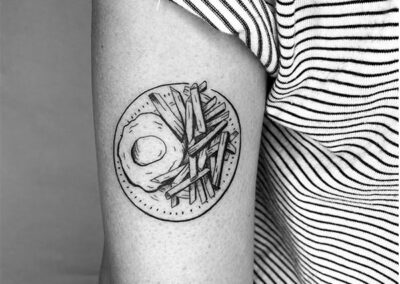 blackwork tattoo de un huevo frito con patatas