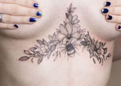 Tatuajes realistas bajo el pecho de una mujer