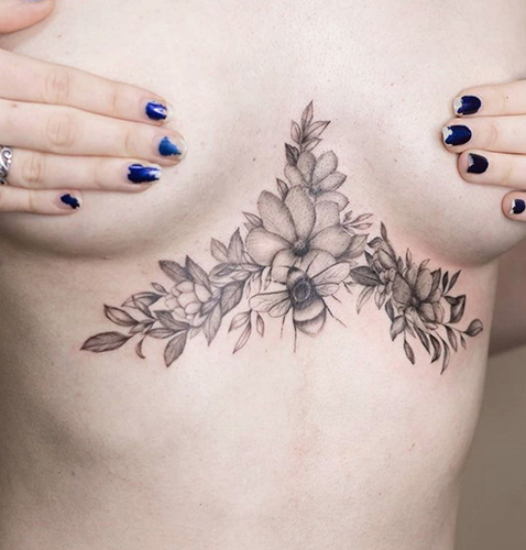 Tatuajes realistas bajo el pecho de una mujer