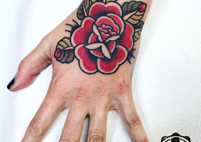 Tatuaje en la mano de una rosa estilo old school