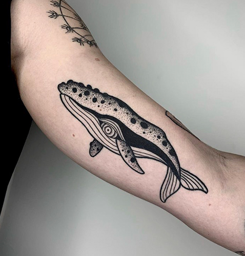 Blackwork tattoo de una ballena en el brazo