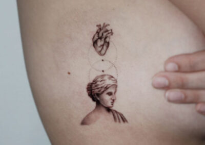 Tatuaje de rostro de perfil estilo griego con corazón encima | tatuaje micro-realista | tatuadores en Madrid