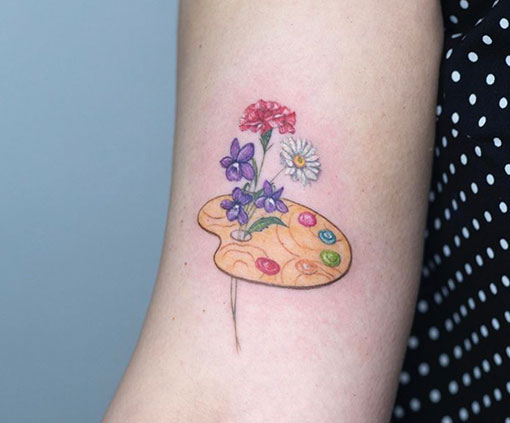 Mini tattoo de paleta de pintura con flores en brazo | Mini tattoo | Estilos de tatuaje | Cornelius Tattoo