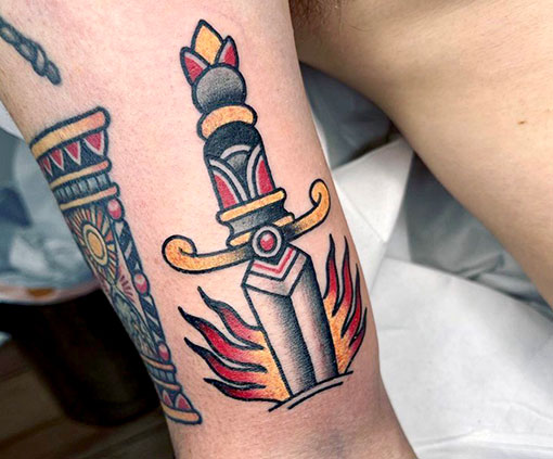 Tatuaje con estilo old school de una espada en un brazo | tatuaje Old School | Estilos de tatuaje | Cornelius Tattoo