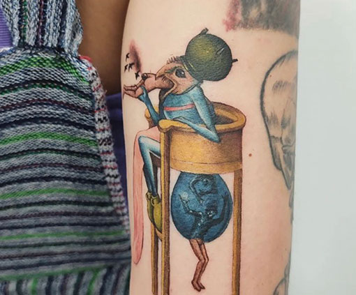 Tatuaje con estilo realista de un insecto sentado en una silla que come y genera personas en un brazo | tatuaje Realista | Estilos de tatuaje | Cornelius Tattoo