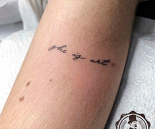 Tatuaje con la frase “she is art” en brazo | Tatuaje frases | Estilos de tatuaje | Cornelius Tattoo