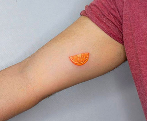 Tatuaje minimalista de una rodaja de naranja en un brazo | Tatuaje minimalista | Estilos de tatuaje | Cornelius Tattoo