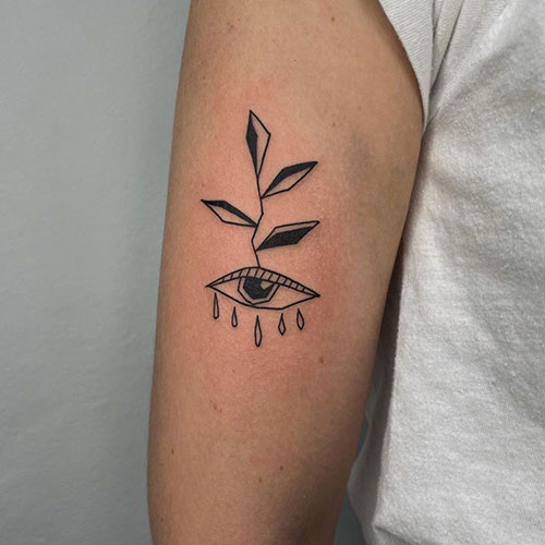 Tatuaje-brazo-hombre-ojo-abstracto tatuaje de la cabeza de un ojo del que nace una planta abstracto | tatuaje brazo hombre | tatuaje en el brazo | tatuarse en Madrid | Cornelius Tattoo