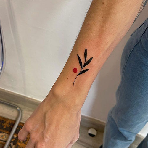 tatuaje-brazo-mujer-planta-punto-rojo tatuaje de un planta y un punto rojo | tatuaje brazo mujer | tatuaje pequeño mujer | tatuarse en Madrid | Cornelius Tattoo