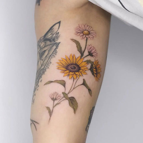 Tatuaje en el brazo de unas flores rosas y un girasol | Tatuadoras Madrid | Tatuaje en el brazo | Tatuajes en Madrid | Cornelius Tattoo